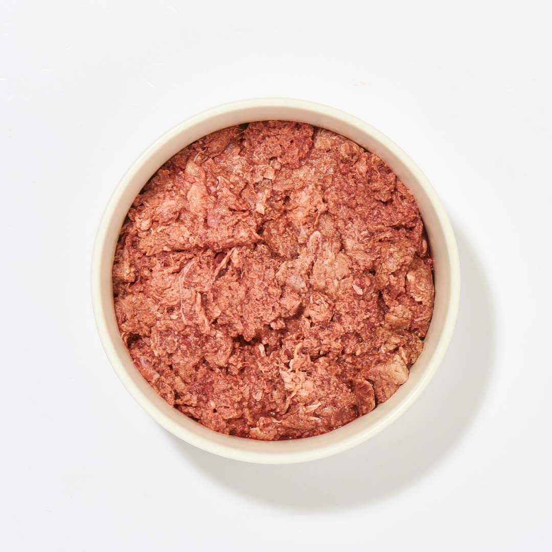 BARF Komfort PLUS Kaninchen dog food in a bowl, featuring a mix of rabbit meat, vegetables, and essential nutrients.